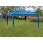 The Draper Concertina Gazebo, 3 x 3M in blue (GAZ2), made of durable splashproof material, is set up on a grassy area with trees and houses visible in the background. Perfect for both commercial and domestic projects, this easy-to-assemble gazebo combines functionality with convenience.
