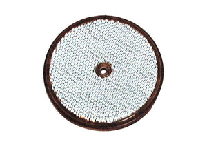 A round, flat object with a perforated, mesh-like white surface and a small central hole. The edge is framed by a dark border. It resembles a disc-shaped filter or sieve.