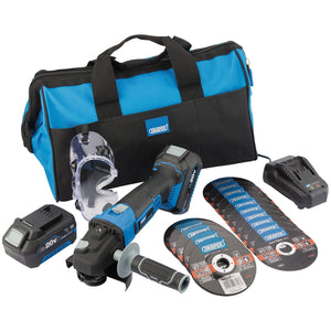 The Draper Storm Force 20V Cordless Grind And Cut Kit - PTKGC20V includes an angle grinder, numerous discs including metal cutting wheels, two battery packs, a charger, safety glasses, and a blue and black carrying bag.