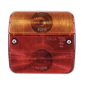 The Draper 12V Rear Light Cluster - TT122 is a rectangular red and amber vehicle taillight featuring circular patterns. It is secured with two screws and has embossed text specifying bulb types P21W and P21/5W. Designed for brake lights, this 12V rear light uses a P21W E4 single filament bulb.