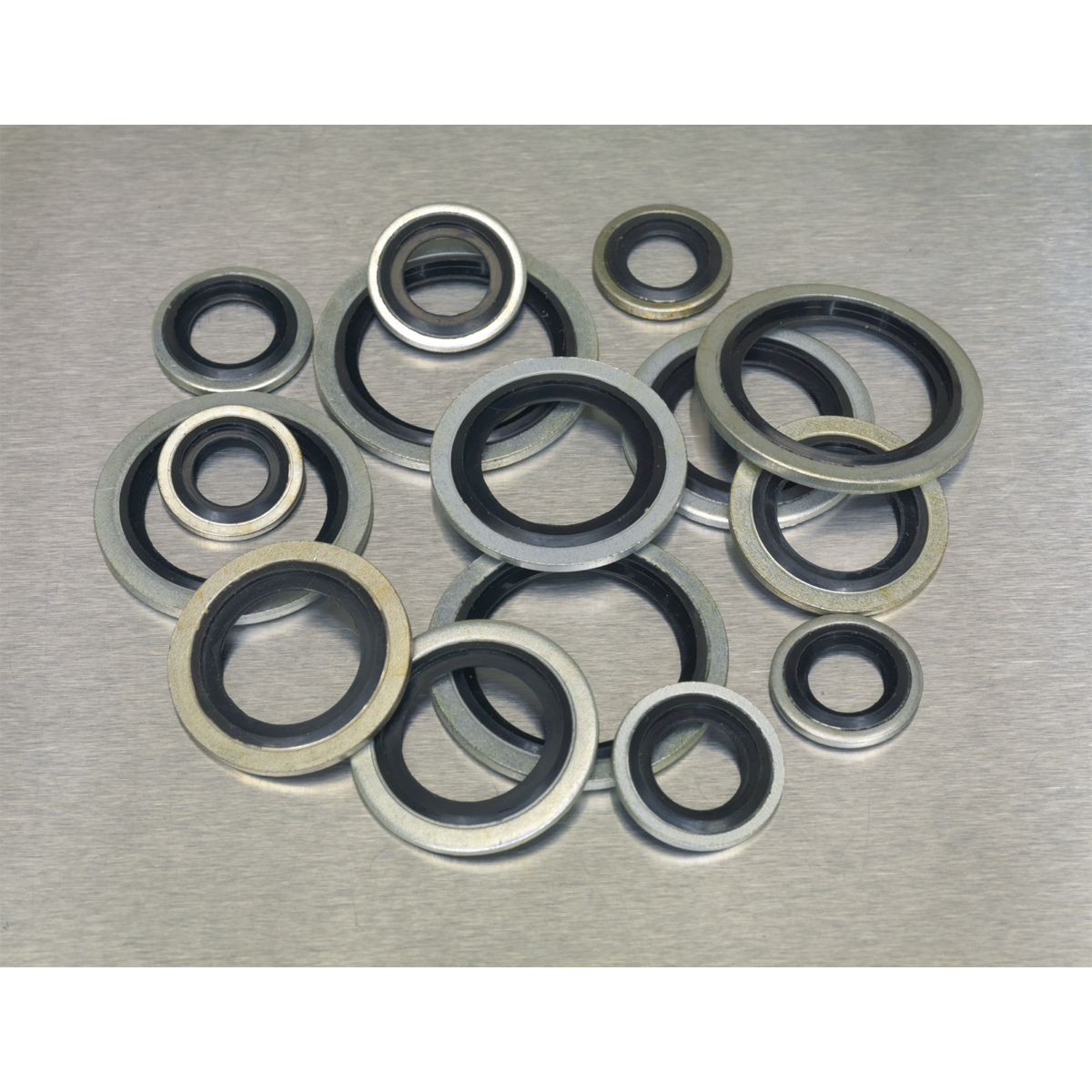 An assortment of 88 mechanical seals, including Dowty Seals and bonded seals, arranged on a flat surface. The product is identified as Sealey's Bonded Seal (Dowty Seal) Assortment 88pc - Metric - AB010DS.