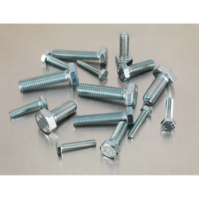 Various sizes of hex bolts, including the comprehensive Sealey Setscrew Assortment 150pc Metric M5-M10 High Tensile - AB048SS adhering to DIN 933 standards, are scattered on a metallic surface, offering an organized yet industrial charm like a partitioned box of tools.
