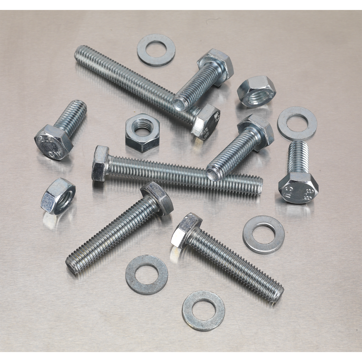 An assortment of Setscrew, Nut & Washer from Sealey, featuring 150 pieces of high-tensile M10 metric components (Product Code: AB052SNW), scattered on a flat, metallic surface.