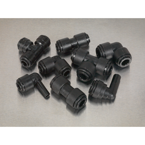 Several black plastic pipe fittings, including elbows and tees, are arranged on a gray surface, featuring Sealey Speedfit® Coupling Assortment 32pc Ø6 & Ø8mm Metric - AB069JG connectors for a secure fit.