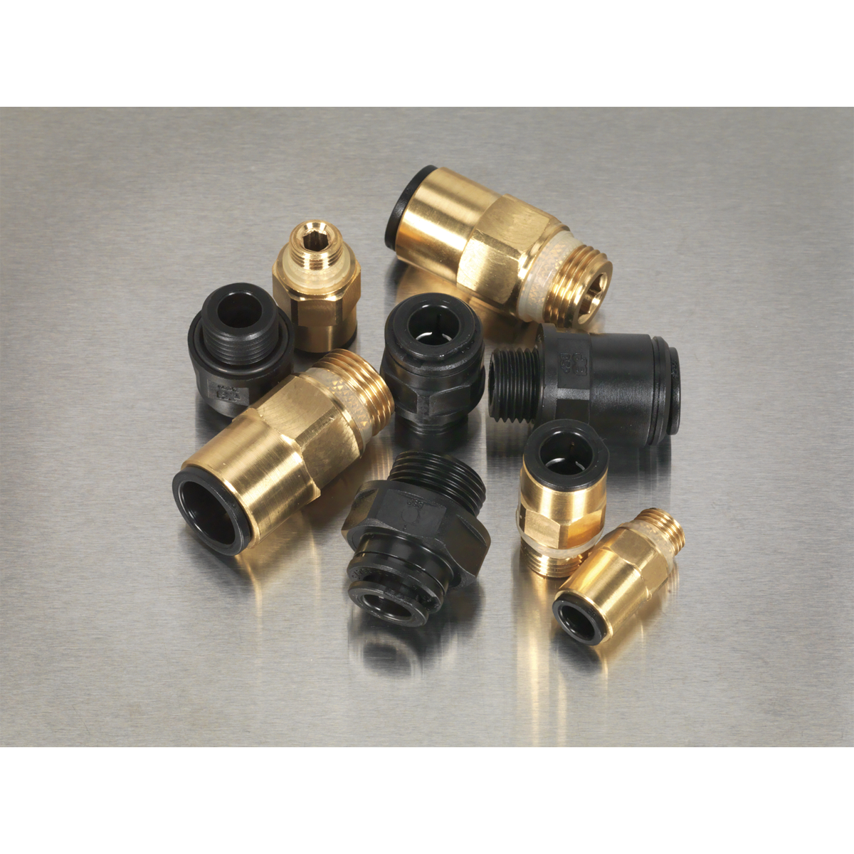 A selection of Sealey Speedfit® Thread Adaptor Assortment 30pc Metric & Imperial - AB072JG brass and black plastic pneumatic fittings, including thread adaptors and Speedfit pneumatic couplings, arranged on a metal surface.