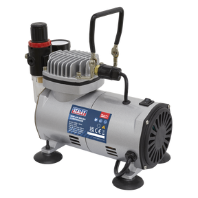 Introducing the Mini Air Brush Compressor - AB900 by Sealey: a silver, quiet running piston pump compressor featuring a black handle, pressure gauge, and red adjustment knob. It is mounted on black rubber feet and adorned with several specification labels. Perfectly designed to provide an oil-free air supply for precise tasks such as airbrushing.