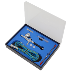 The Sealey Air Brush Kit Gravity Feed - AB9321 features a metal body, double-action trigger, 0.3mm nozzle, hose, cleaning brush, pipette, wrench, and two small containers all neatly packaged in a foam-lined box with a transparent lid.