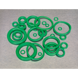 A collection of Sealey's Air Conditioning Rubber O-Rings, 225 pieces in various metric sizes, meticulously arranged on a gray surface. These green HNBR O-rings are ideal for automotive air conditioning systems using Freon R134a.