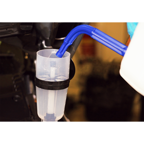 An AdBlue® Filling Funnel - Straight - ADB07S from Sealey, featuring a blue flexible spout, is inserted into a container. Water or clear liquid is being poured through the large capacity funnel.