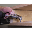 A person uses the Sealey Angle Driver - AK2104 on a power drill with magnetic bit retention to drive a screw into a corner of a piece of wood.