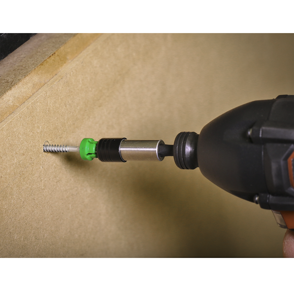 Using the Sealey Power Tool Bit Pozi #2 with Magnetic Holder S2 25mm (Pack of 5 - AK210521), a power drill drives a screw into a piece of wood, featuring high-quality S2 steel and a convenient green and black design.