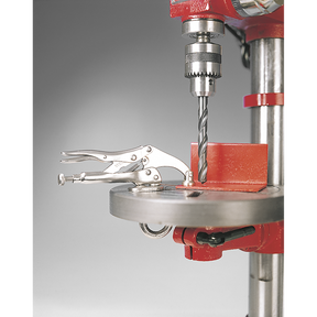A Sealey Drilling Machine Work Grip 230mm - AK214, equipped with a metal bit, is set up for drilling. The platform securely holds a small part in place using a quick clamp.