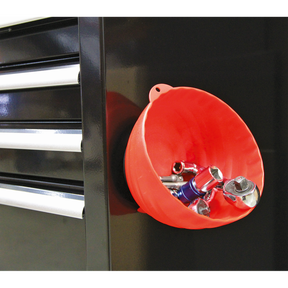 The Sealey Magnetic Collector Ø150mm Red (AK2319), featuring a magnet in a non-marking cover, holds various metal tools and is attached to the side of a black tool chest with three drawers.