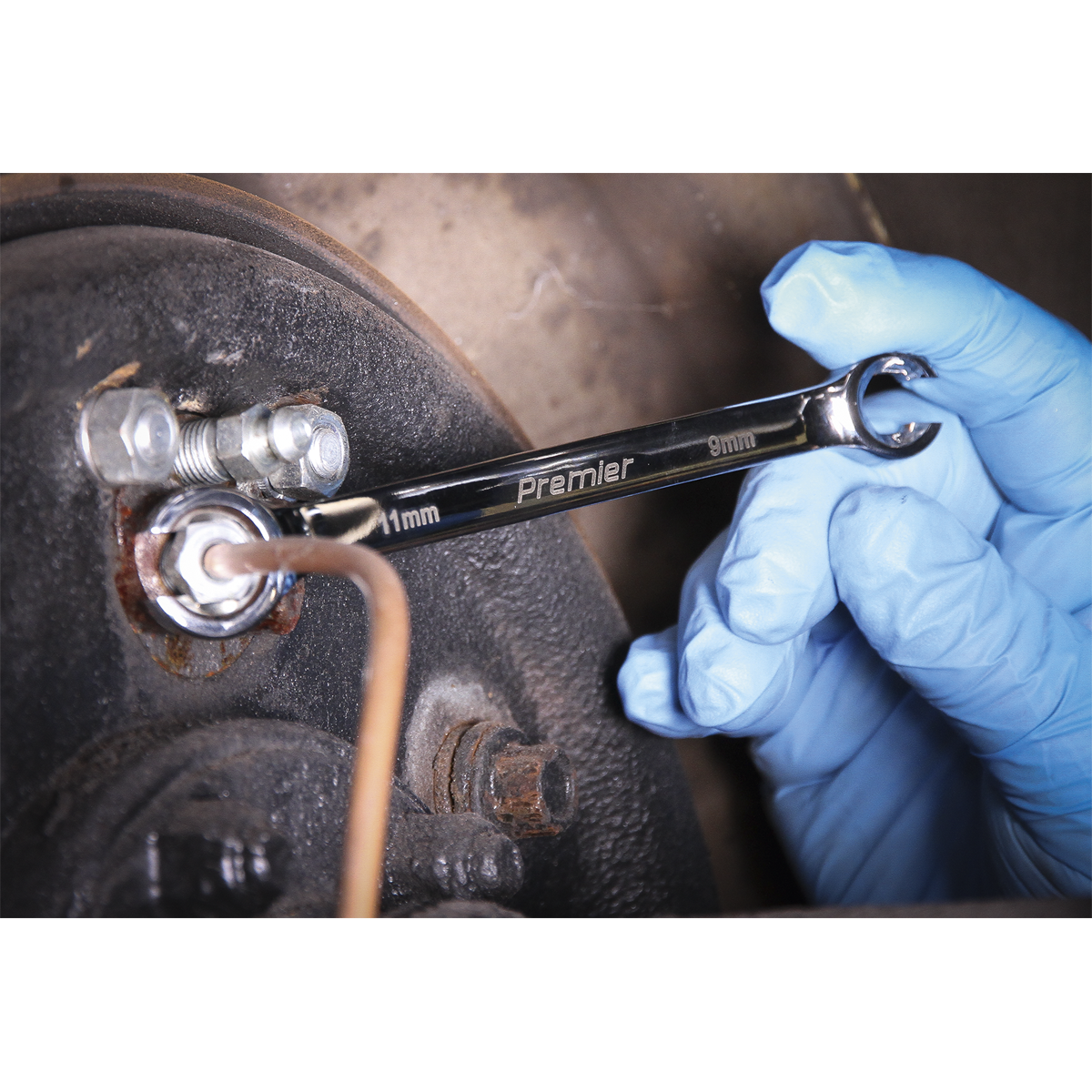 A gloved hand using a Sealey 9mm spanner from the Flare Nut Spanner Set 5pc Metric - AK2651 on a bolt.