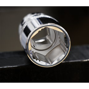 Close-up of a Sealey Socket Set 13pc 1/2"Sq Drive Lock-On™ 6pt Metric - AK2742 chrome socket wrench head against a dark background, displaying a hexagonal opening with detailed serrations inside, ideal for handling rounded fasteners.