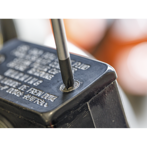 Close-up of the tip from the Sealey Screwdriver Set 4pc JIS - AK4314 inserted into a Japanese Industrial Standard screw on a black, metal surface. Text and warnings are partially visible on the surface.
