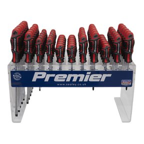 A display of multiple GripMAX® screwdrivers with ergonomic red and black soft grip handles, arranged in rows on a transparent stand labeled "Premier Hand Tools" featuring the Sealey logo and website. Made from durable Chrome Vanadium steel, these tools ensure precision and comfort for every project. This setup showcases the Individual Screwdrivers GripMAX® 66pc Countertop Display - AK4369DS by Sealey.