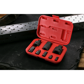 A red plastic case from Sealey, specifically the Impact Socket Adaptor Set 8pc - AK5900B, is open and displayed on a dark surface. The set includes various black metal hole saws of different sizes and impact adaptors made from durable Chrome Vanadium steel to ensure longevity and performance.