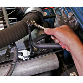 A hand using a Sealey Crow's Foot Wrench Adjustable 3/8" Sq Drive 6-30mm - AK5987, crafted from durable Chrome Molybdenum steel, to tighten or loosen a bolt on an engine component.