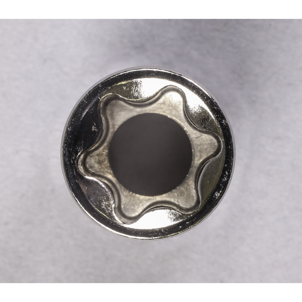 Top view of a six-pointed star-shaped metal object from the Sealey TRX-Star* Socket Set (14pc, 1/4", 3/8" & 1/2"Sq Drive E4-E24 - AK618), made from Chrome Vanadium steel with a hollow center and exceptional corrosion resistance, set against a plain, light-colored background.