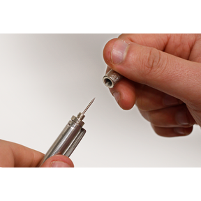 Close-up of hands holding and assembling a Sealey Magnetic Pick-Up Tool 1.6kg Capacity - AK6516, with one hand screwing a cap onto the needle-like device.