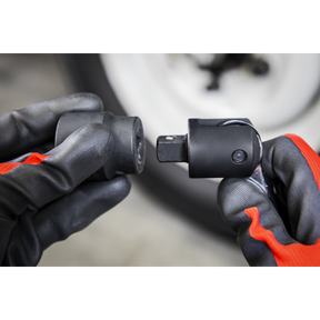 Close-up of gloved hands holding two interconnecting parts of the Sealey Breaker Bar 600mm 1/2"Sq Drive - Hi-Vis Green (AK7306HV) with a soft grip handle against a blurred background.