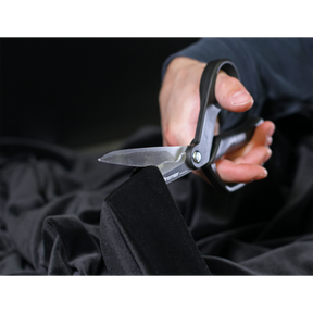 The Sealey Shears/Scissors 250mm Heavy-Duty - AK8524 with ergonomic handles effortlessly cut through black fabric.