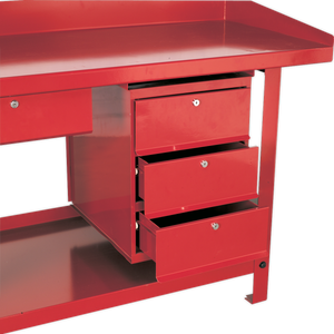 The Sealey 3 Drawer Unit for AP10 & AP30 Series Benches - AP3 is a red, metal workbench known for its industrial durability. It features three partially open drawers on the right side and one closed drawer on the left. The bench has a flat surface with slightly raised edges, providing ample drawer space for tools and materials.