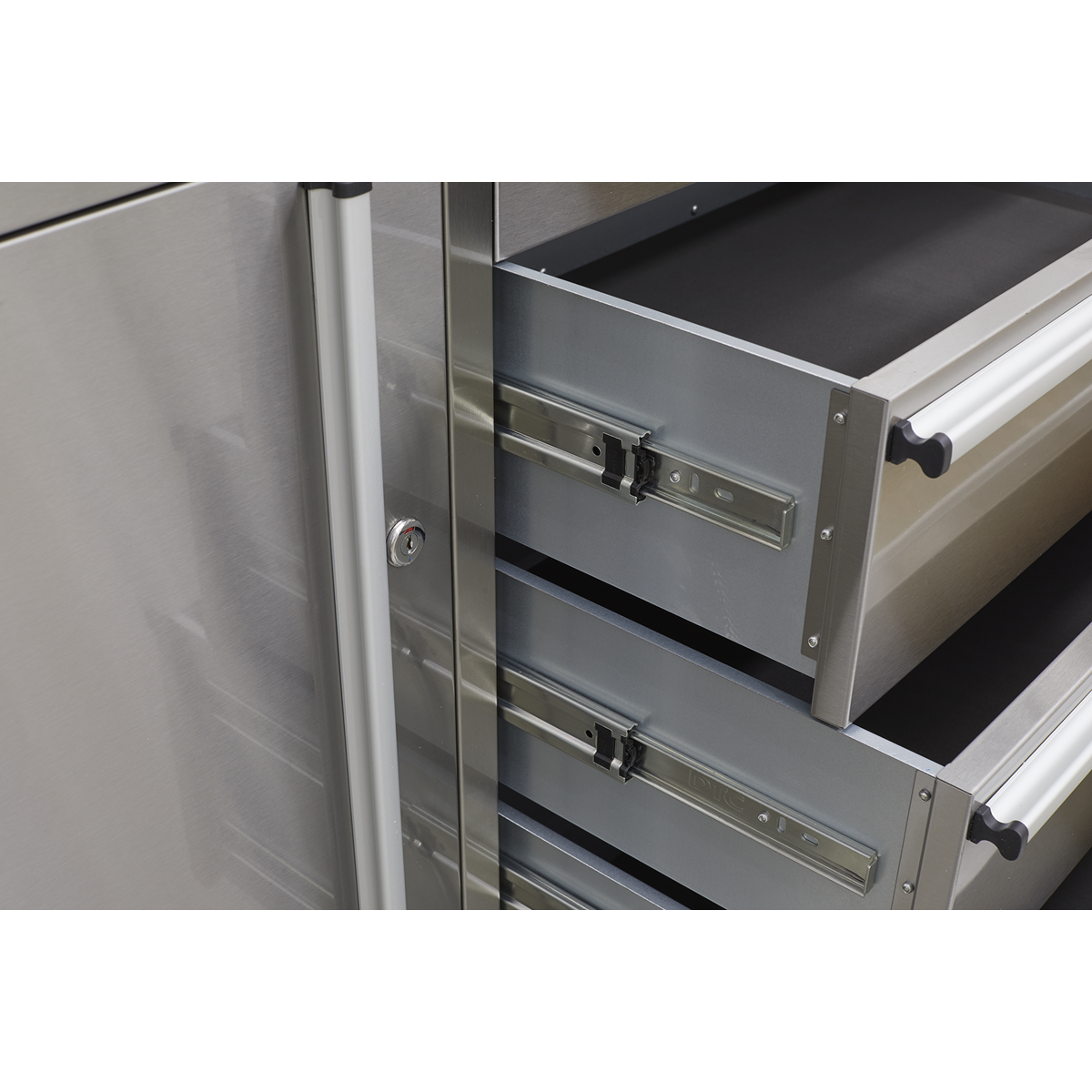 A close-up view of an open Sealey Mobile Stainless Steel Tool Cabinet 4 Drawer - AP4804SS with a wooden worktop, showcasing three drawers with sliding mechanisms and anti-fingerprint stainless steel handles.