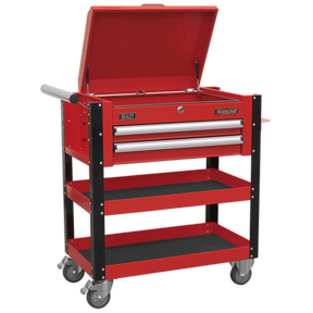The Sealey Heavy-Duty Mobile Tool & Parts Trolley 2 Drawers & Lockable Top - Red - AP760M is a red workshop trolley featuring an open top compartment, a lockable lid, two drawers, and two shelves. It also comes equipped with a handle on the left side and smooth wheels for easy maneuverability.