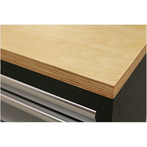 Close-up of a Sealey Pressed Wood Worktop 2040mm - APMS50WC edge atop a black metal drawer unit with a visible drawer handle from our APMS Floor Cabinets, backed by a 5-Year Guarantee.