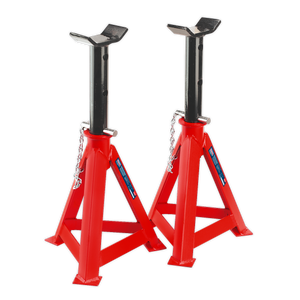 Sealey's Axle Stands (Pair) AS10000, each with a 10-tonne capacity, feature a red and black design with saddle-shaped tops and triangular bases, interconnected by safety chains. These steel stands ensure reliable load support while meeting stringent safety standards.