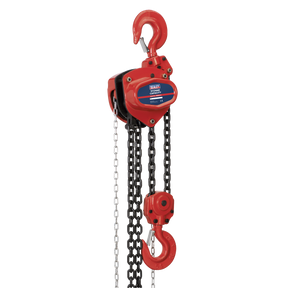 The Sealey Chain Block 5 Tonne 3m - CB5000 is a red manual chain hoist featuring two hooks, one at the top and one at the bottom, connected by heavy-duty black chains. Made from hardened alloy material, it includes a mechanical load brake for enhanced safety and control.