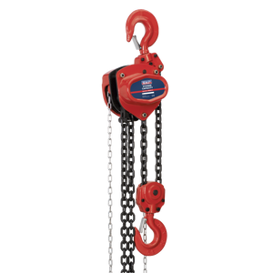 The Sealey Chain Block 5 Tonne 3m - CB5000 is a red manual chain hoist featuring two hooks, one at the top and one at the bottom, connected by heavy-duty black chains. Made from hardened alloy material, it includes a mechanical load brake for enhanced safety and control.