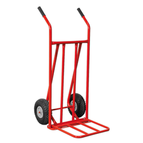 The Sealey Sack Truck with Pneumatic Tyres Folding 150kg Capacity - CST800, featuring a robust metal frame and two black pneumatic tyres, is ideal for navigating rough terrain or uneven surfaces.