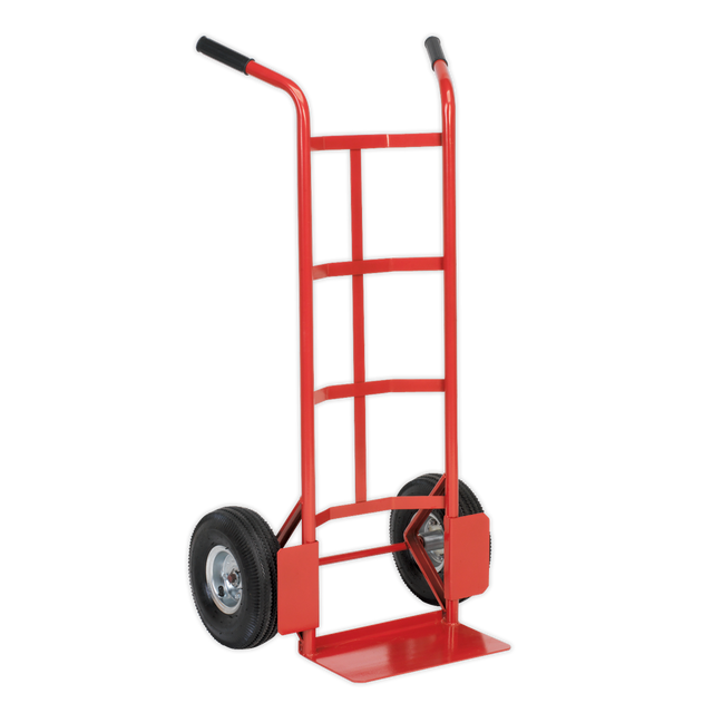 The Sealey Sack Truck with Pneumatic Tyres 200kg Capacity - CST986 is a red and black hand truck with a tubular steel frame, featuring two large black pneumatic tyres and a flat base for lifting and transporting items.