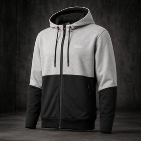 A men's colorblock zip-up hoodie with a light gray upper body and hood, black lower body and sleeves, and a black front zipper, shown against a dark textured studio background.
