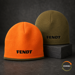 Two knit beanie hats on a dark textured surface: one bright orange in front with black FENDT embroidery, and one olive green behind on a dark block, also with black FENDT embroidery. A small 'Reversible' badge appears in the lower right.