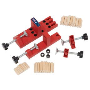 The Sealey Universal Dowelling Jig Set - DJ01 includes red corner clamps, several wooden dowels, clamp screws, and plastic spacers, making it ideal for creating precise dowel joints; all displayed on a white background.