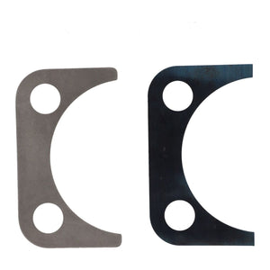 Two AGCO Disc - F718301020290 metal shims with similar shapes; the left one is silver and the right one is black. Both have two circular holes near the top corners and a curved cutout on the bottom. These components are commonly used in Massey Ferguson Models like the MF 6615 for precise fitting in Dyna-6 transmissions.