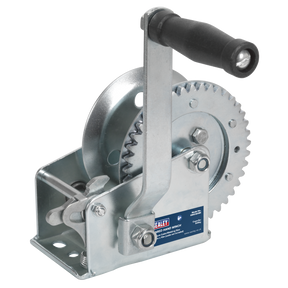Close-up of the Sealey Geared Hand Winch 540kg Capacity - GWE1200M with a black handle, single gear mechanism, and hardened steel gears. A blue label on the side indicates the brand Sealey. The winch also features a manual brake, designed for lifting or pulling heavy loads.