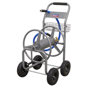 Introducing the Hose Reel Cart Heavy-Duty - HRCHD by Sealey: a four-wheeled cart constructed from lightweight tubular steel, designed for durable and efficient water hose storage. It features a black handle, a blue hose, a metal hose reel, puncture-proof wheels, and includes a small basket attached behind the reel.