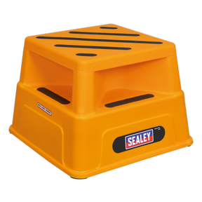 The Platform Safety Step Heavy-Duty - KS5 by Sealey is a yellow plastic safety step featuring black stripes on its large step surface. It includes cutout handles on the sides and proudly displays the "Sealey" logo on the front, offering stability and ease of use.