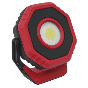 The Sealey Rechargeable Pocket Floodlight with Magnet 360° 7W COB LED in red (LED700PR) is a red and black hexagonal work light with a stand, featuring a central circular light source and powered by a reliable lithium-ion battery.