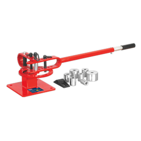 The Sealey Metal Bender Bench Mounting - PBB04, a red manual metal bender with a long handle and multiple interchangeable dies for creating radiused bends, is lying beside it on a white background.