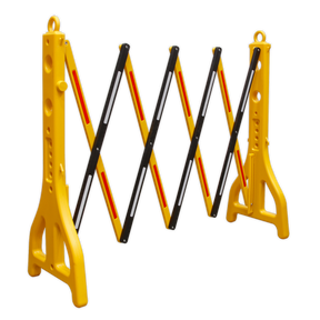 A Sealey Folding Barrier 2500mm Plastic - PFB2500 in yellow and black, featuring perforated legs for stability, a weighted base, and a diagonal crisscross pattern with reflective strips.