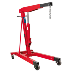The Sealey Fixed Frame Engine Crane with Extendable Legs 3 Tonne - PH30 is a red hydraulic hoist featuring a lifting arm, hook, and chain. Designed for industrial use, it boasts a wheeled base with heavy-duty castors for mobility and an adjustable boom that can handle heavy engines and machinery up to a 3000kg lifting capacity.