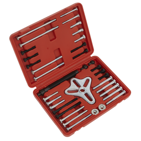 A red plastic storage case from Sealey, containing the Harmonic Balancer Puller Set 49pc - PS979, includes bolts, rods, and a three-pronged pulling device for extracting flywheels. The case is open to display the neatly organized tools.