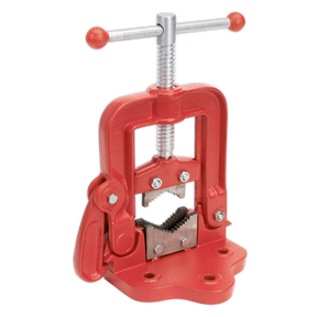An 85mm bench model pipe vise, the PV63B by Sealey, features a red finish with a turning handle and serrated jaws designed to securely clamp and hold pipes or electrical conduits in place.