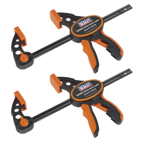 Two Sealey Quick Bar Clamp 150mm clamps, part of the QBC1502 two-piece set, are displayed against a white background. The heavy-duty clamps feature black and orange handles and are designed for quick one-handed operation. They are positioned parallel to each other, showcasing both front and side views.